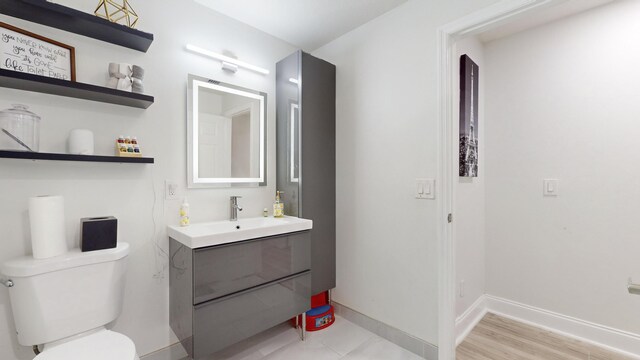 bathroom featuring vanity, wood-type flooring, and toilet