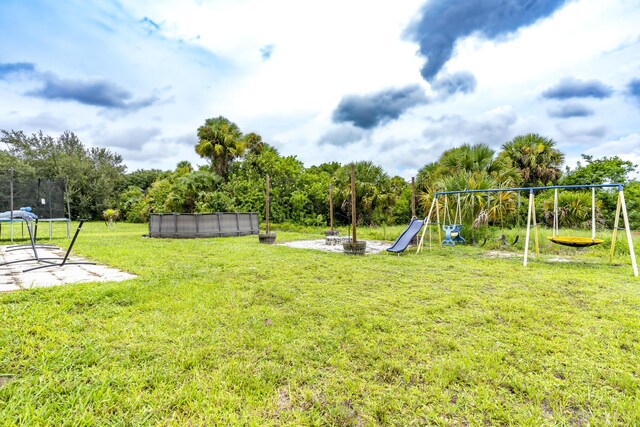 view of yard with a playground and a swimming pool