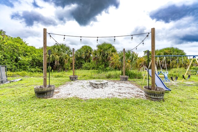 view of yard with a playground and a fire pit