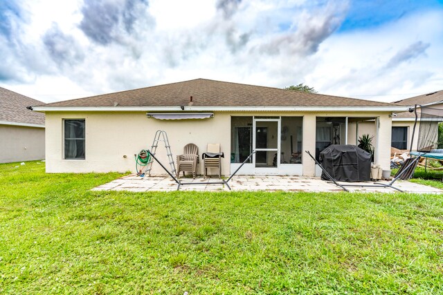 rear view of house featuring a patio and a lawn