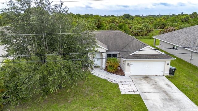 view of front of house featuring driveway, roof with shingles, an attached garage, a front yard, and stucco siding