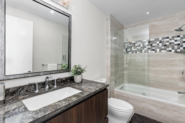 full bathroom featuring vanity, shower / bath combination with glass door, and toilet