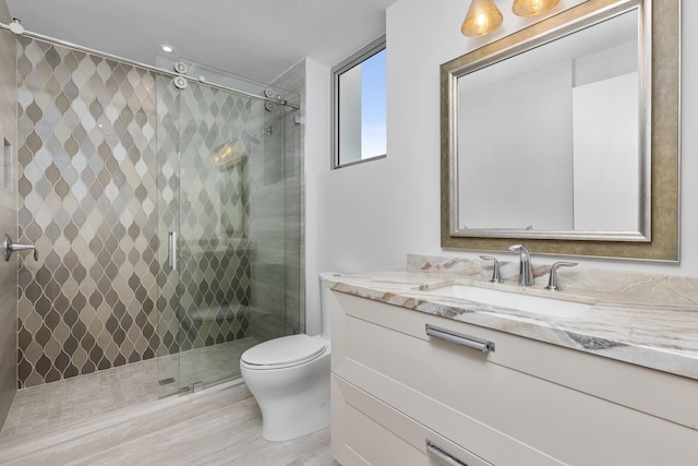 bathroom featuring vanity, walk in shower, and toilet