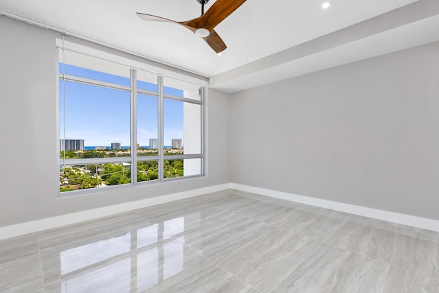 tiled empty room featuring ceiling fan