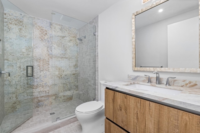 bathroom featuring tile patterned floors, vanity, an enclosed shower, and toilet