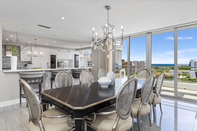 dining space featuring a notable chandelier, sink, and light tile patterned flooring