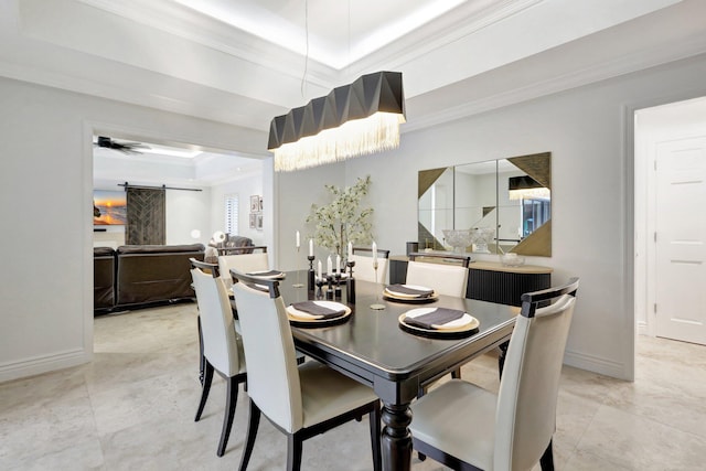 dining space with ceiling fan, ornamental molding, a tray ceiling, and a barn door