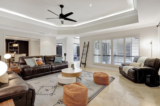 living room with a raised ceiling, ornamental molding, and ceiling fan