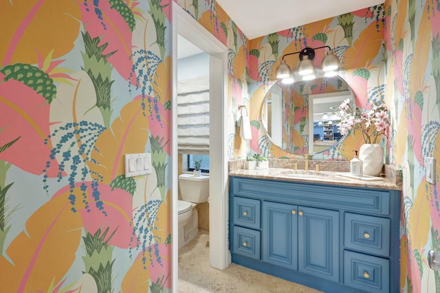 bathroom with vanity, toilet, and a chandelier