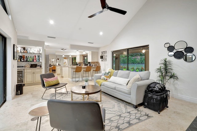 tiled living room featuring ceiling fan, indoor bar, and high vaulted ceiling