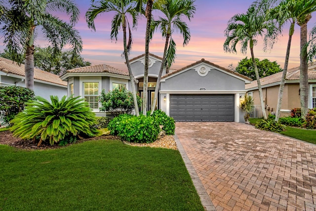 view of front of home with a yard and a garage