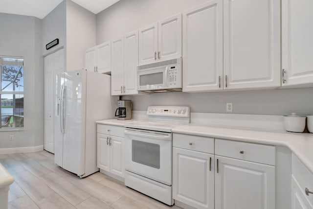 kitchen with white cabinets, white appliances, and light hardwood / wood-style floors