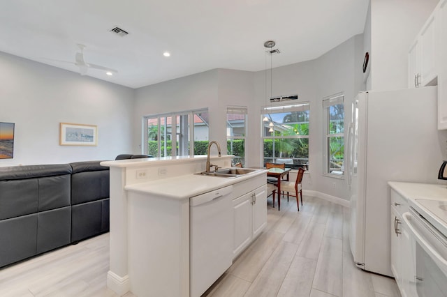 kitchen featuring white cabinetry, white appliances, sink, and hanging light fixtures