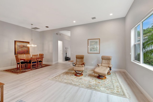 living area featuring a notable chandelier and light hardwood / wood-style floors