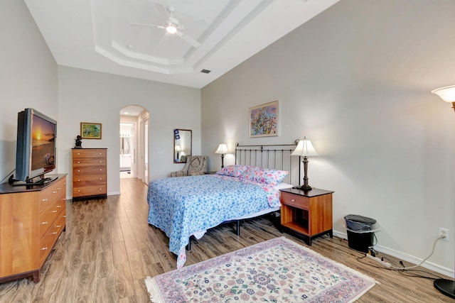 bedroom with a tray ceiling, ceiling fan, and hardwood / wood-style floors