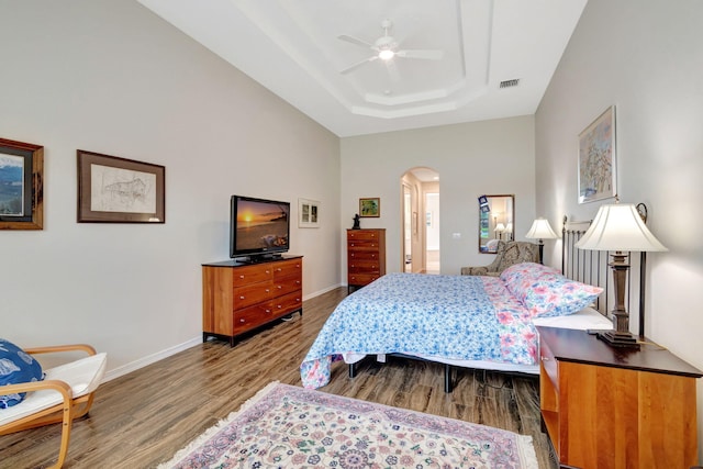 bedroom featuring ceiling fan, hardwood / wood-style floors, and a tray ceiling