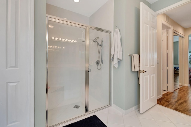 bathroom featuring hardwood / wood-style floors and a shower with shower door