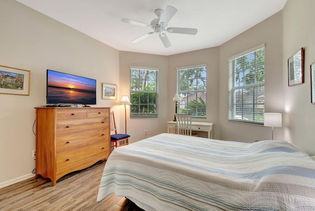 bedroom with ceiling fan, hardwood / wood-style floors, and multiple windows