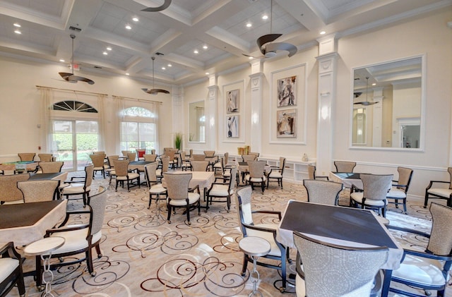 dining area featuring coffered ceiling, beamed ceiling, ceiling fan, and a high ceiling