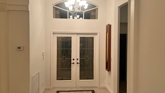 doorway featuring an inviting chandelier and light tile patterned floors