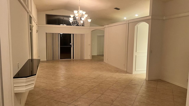 empty room featuring light tile patterned floors, a chandelier, and vaulted ceiling