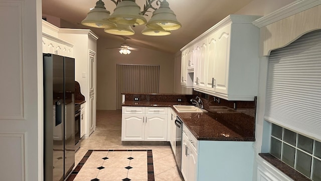 kitchen featuring appliances with stainless steel finishes, ceiling fan with notable chandelier, vaulted ceiling, and white cabinetry