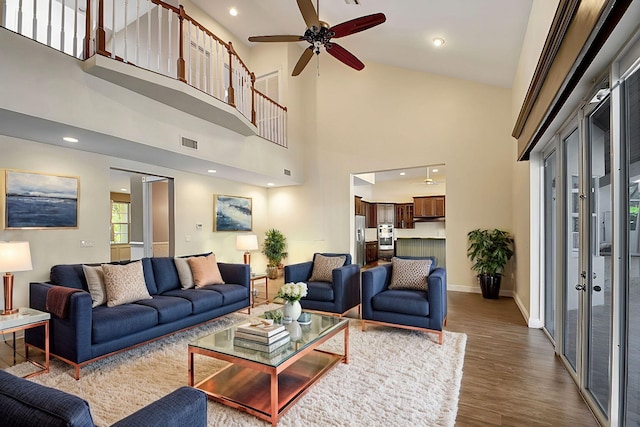 living room featuring ceiling fan, wood-type flooring, and high vaulted ceiling