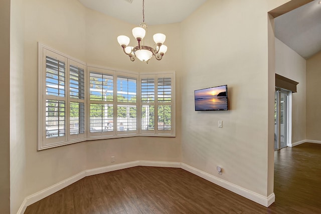 empty room featuring dark hardwood / wood-style flooring and a chandelier