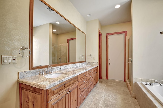 bathroom with vanity and independent shower and bath