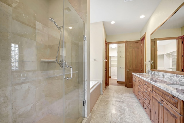 bathroom featuring vanity and independent shower and bath