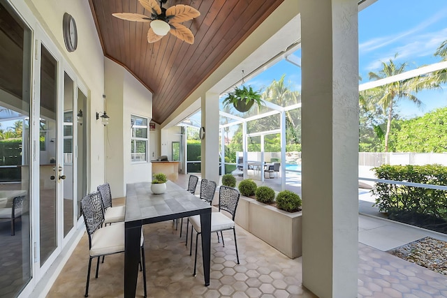 sunroom with a healthy amount of sunlight, ceiling fan, and wooden ceiling