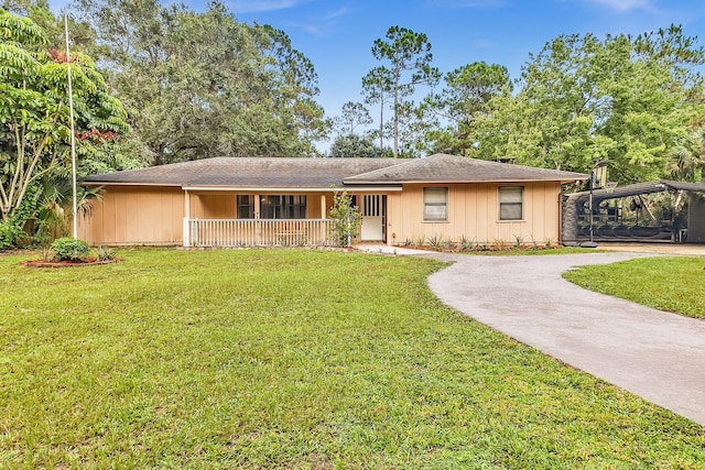 ranch-style home featuring covered porch and a front lawn