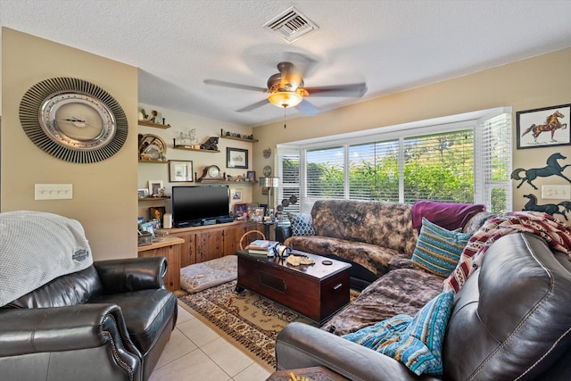 tiled living room featuring a textured ceiling and ceiling fan