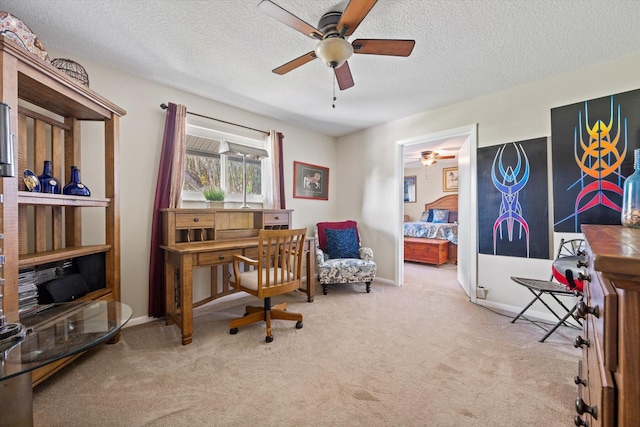 office with a textured ceiling, ceiling fan, and light colored carpet