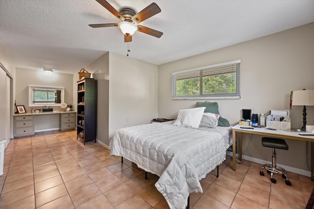 tiled bedroom featuring a textured ceiling and ceiling fan