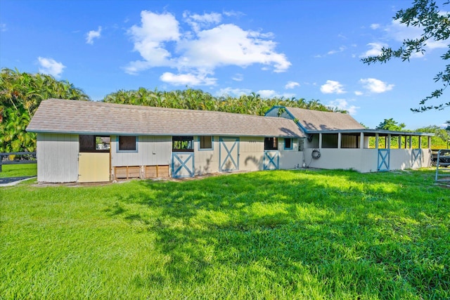 rear view of property with a yard and an outbuilding