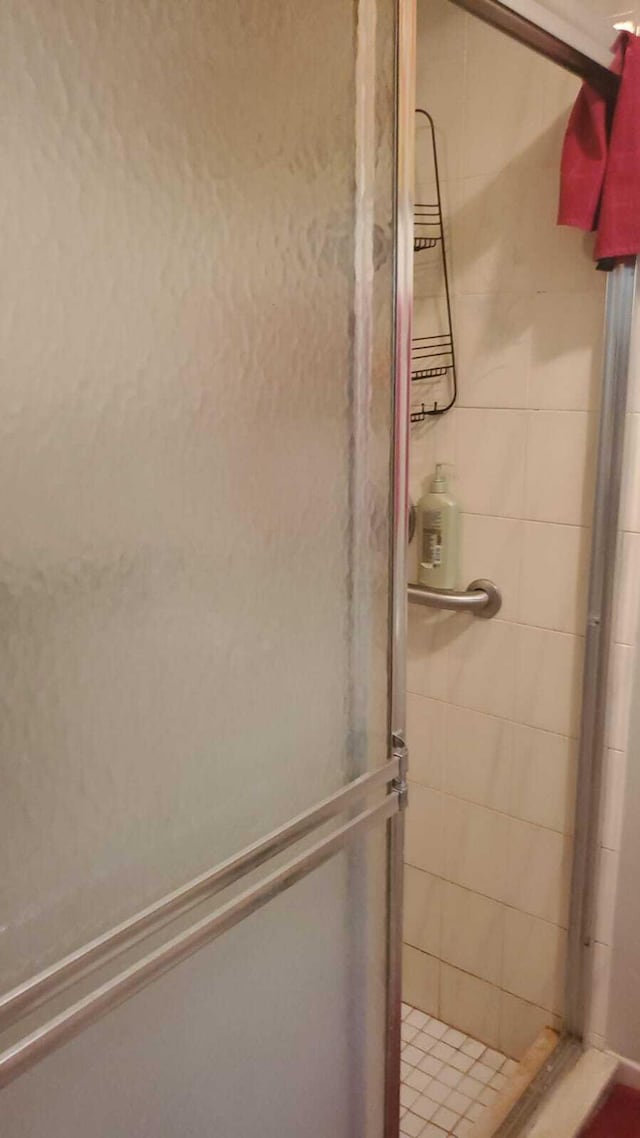 bathroom with a shower with door