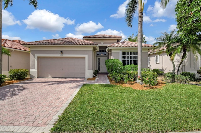 mediterranean / spanish-style home featuring a garage and a front yard