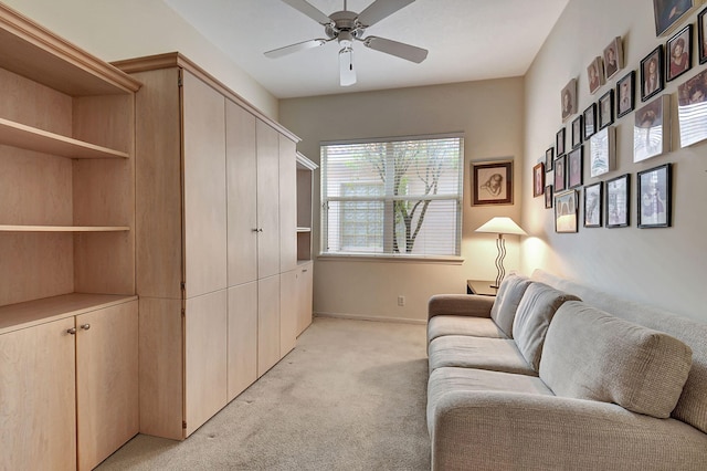 living area with light carpet and ceiling fan