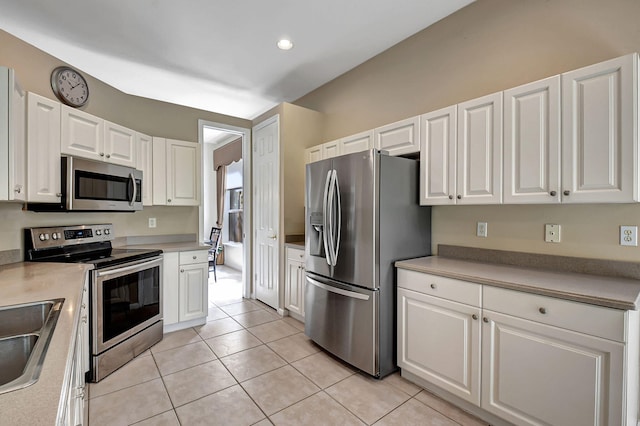 kitchen with light tile patterned flooring, white cabinetry, and stainless steel appliances