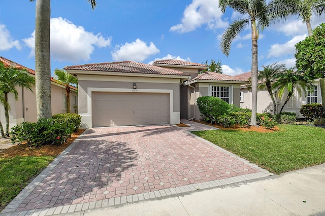 mediterranean / spanish-style house featuring a garage and a front lawn