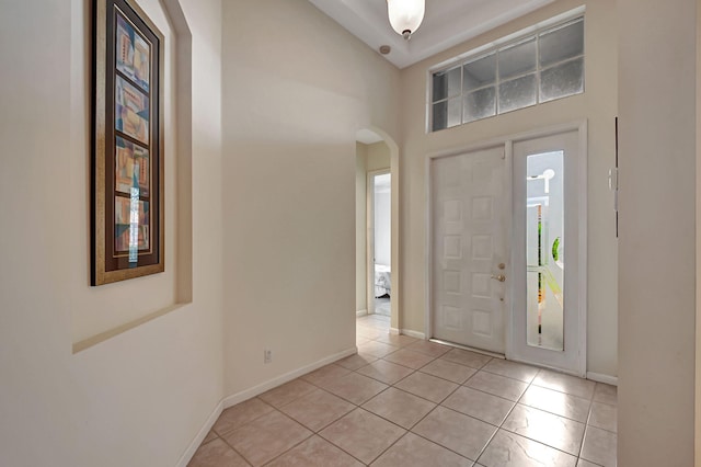 tiled foyer featuring high vaulted ceiling