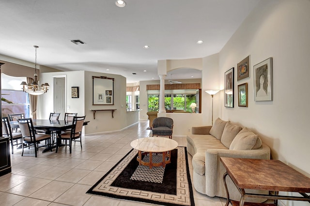 tiled living room featuring a chandelier and ornate columns