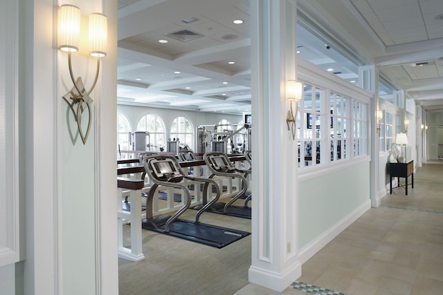 workout area featuring light tile patterned flooring and coffered ceiling