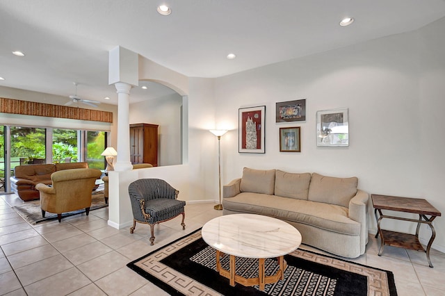 living room featuring light tile patterned floors, decorative columns, and ceiling fan