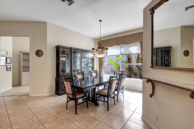 tiled dining space featuring a chandelier