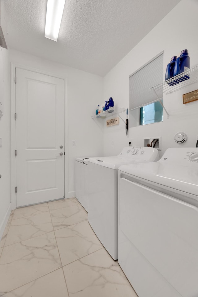 washroom featuring washing machine and dryer and a textured ceiling