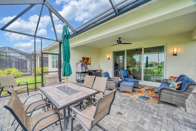 view of patio with ceiling fan, an outdoor hangout area, and glass enclosure