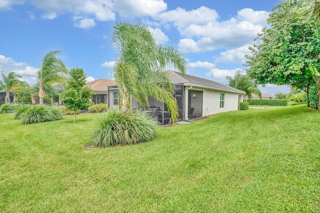 rear view of property featuring a lawn and a sunroom