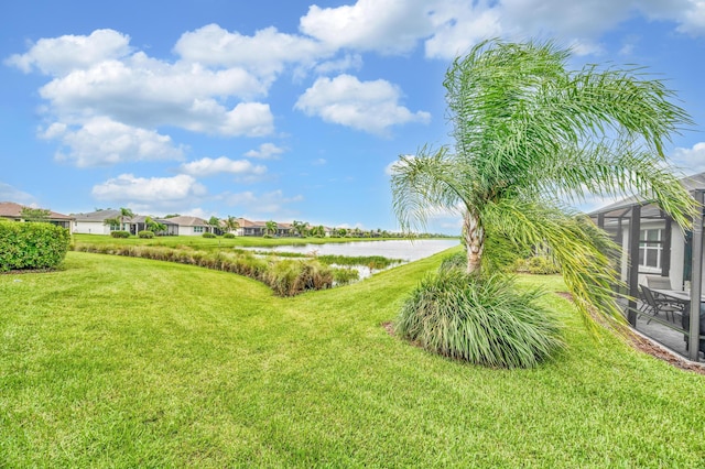 view of yard featuring a water view and glass enclosure